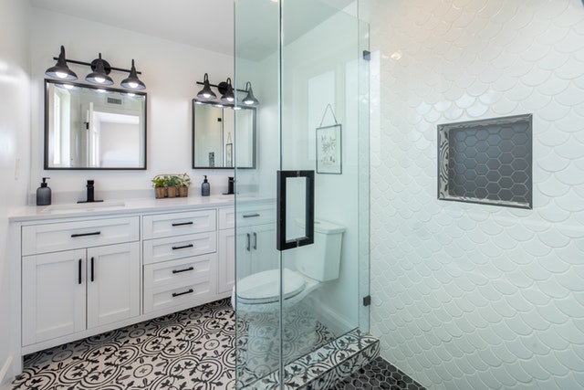 Kúpeľňa s bielym nábytkom, bielymi stenami a sklenenou.jpg