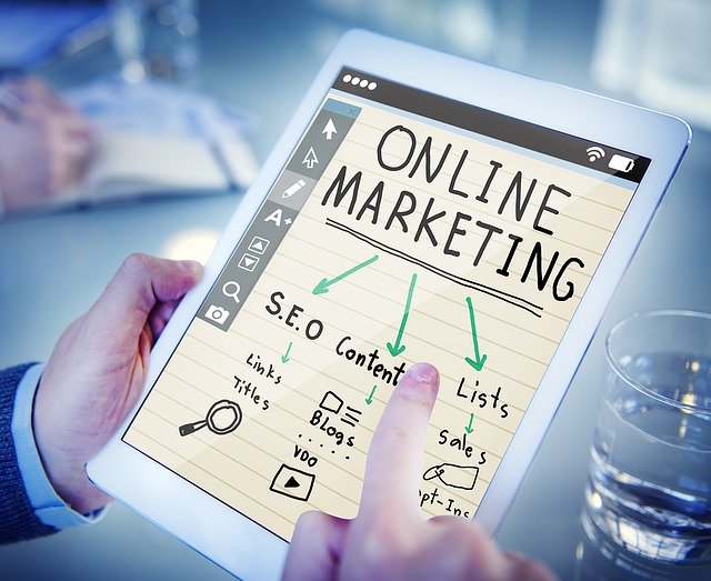 Muž drží tablet s nápisom online marketing
